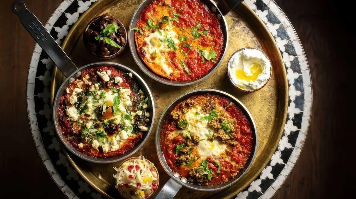 Rotes und grünes Shakshuka in Eisenpfannen auf einem Messingtablett im Nana in München-Haidhausen