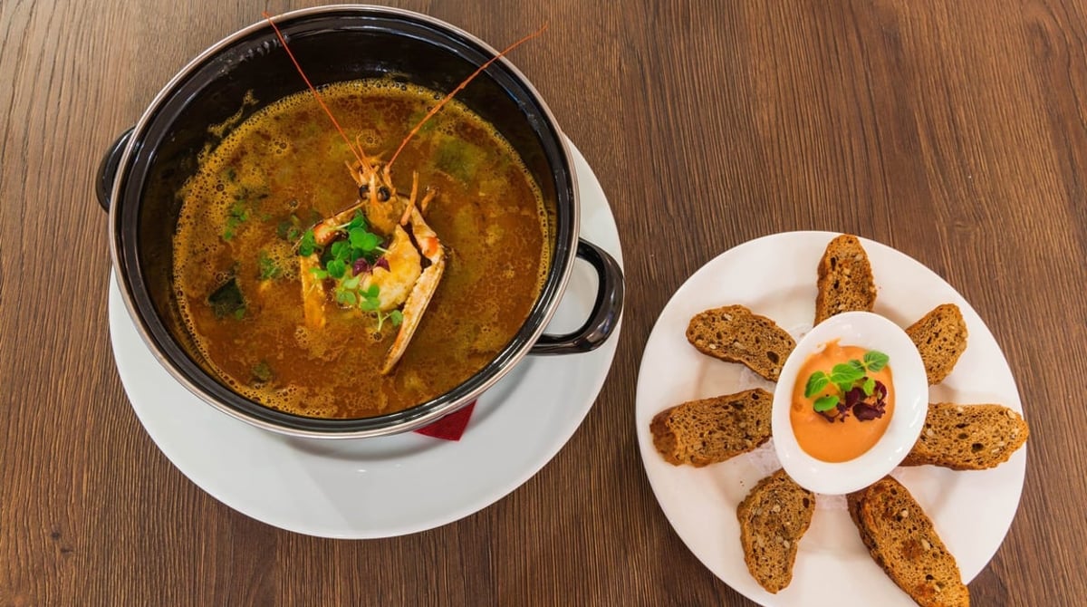 Fischsuppe im Topf mit Croûtons und Rouille
