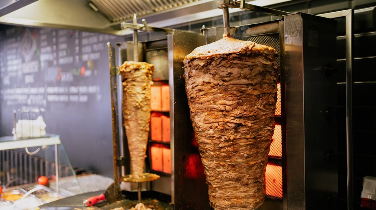 Zwei Dönerspieße drehen sich am Grill hinter der Theke von Django's in Giesing