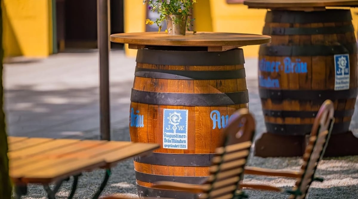 Bierfass als Stehtisch mit Augustiner-Aufdruck vor dem Gutshaus