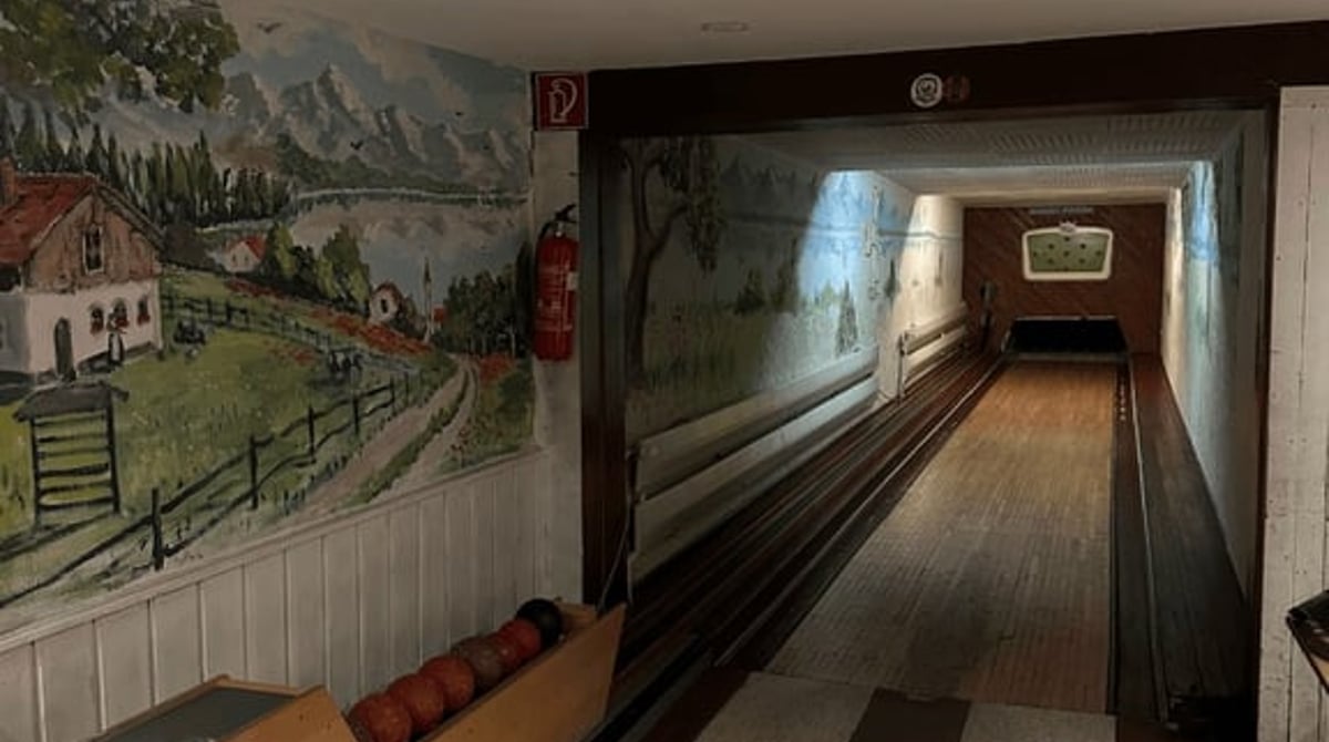 Die Kegelbahn der Pizzeria La Migliore mit Wandbild einer Almlandschaft