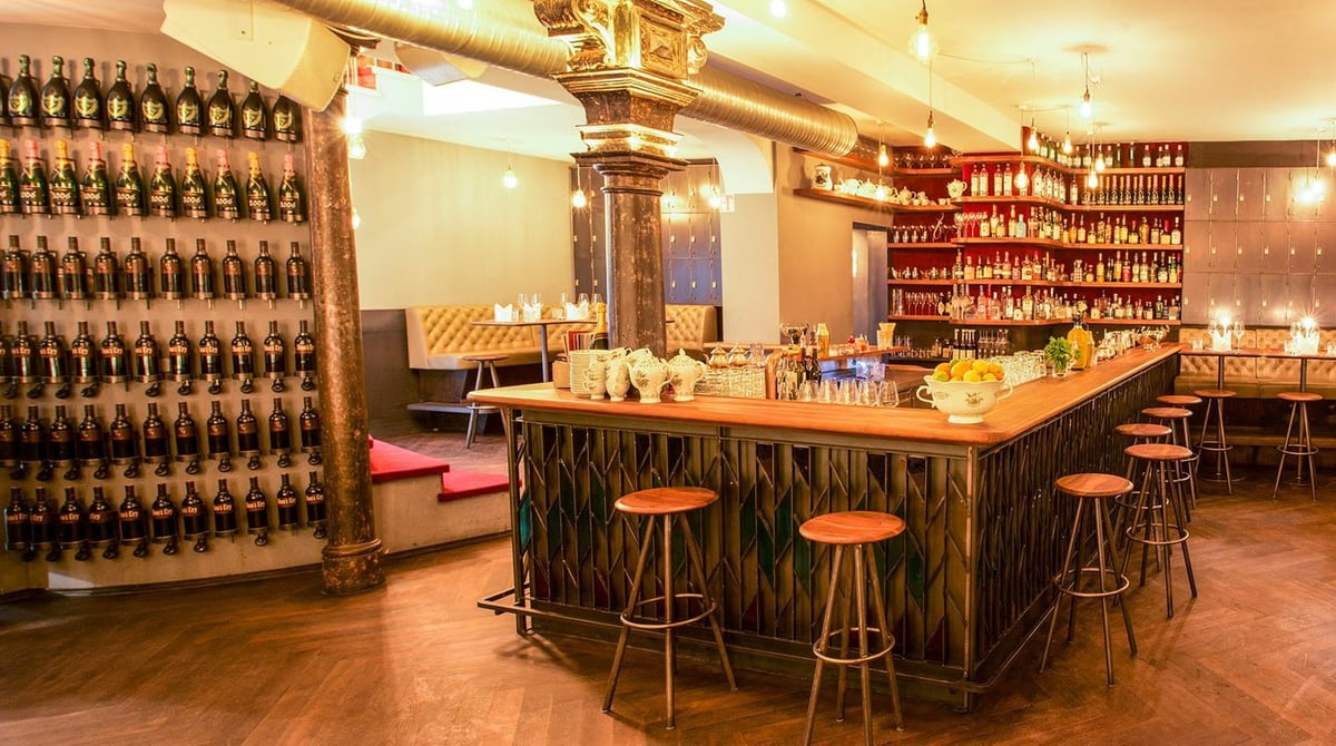 Bar der Burger & Lobster Bank mit Barhockern, Flaschenregalen und Weinwand