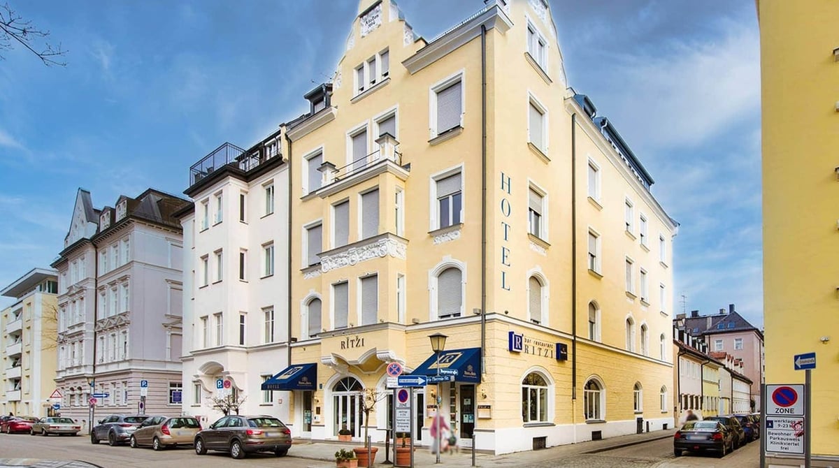 Hotel Ritzi an der Ecke Maria-Theresia-Straße mit gelber Fassade und blauen Markisen