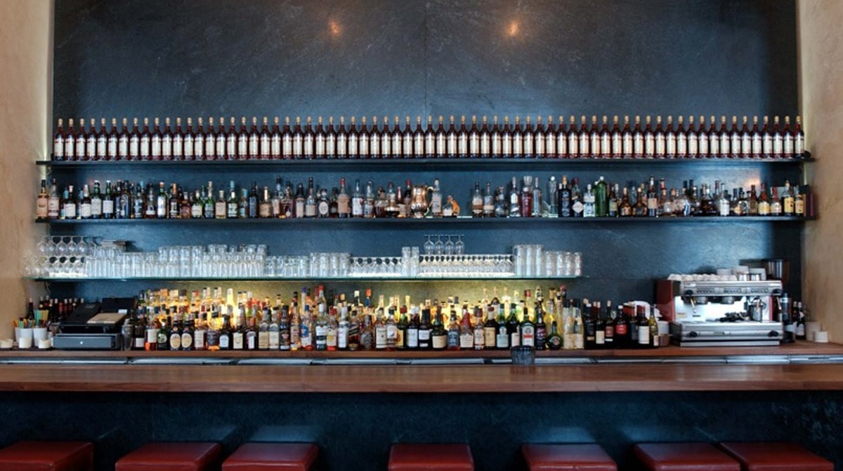 Blick auf die Bar mit Flaschenregal über dem Tresen