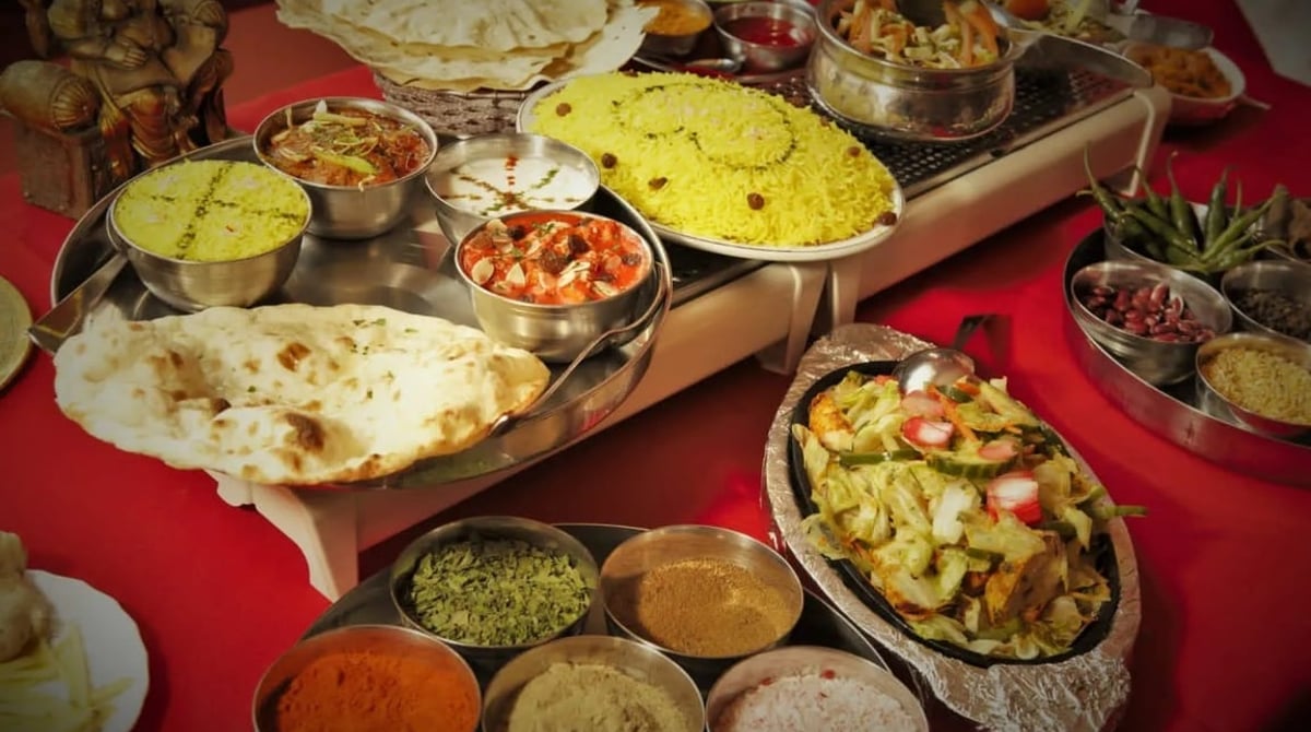 Üppiges Buffet mit Naan, Reis, Linsen und Currys in Metallschalen
