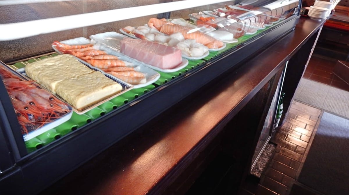 Sushi-Vitrine am Tresen mit Nigiri, Tamago und Fisch