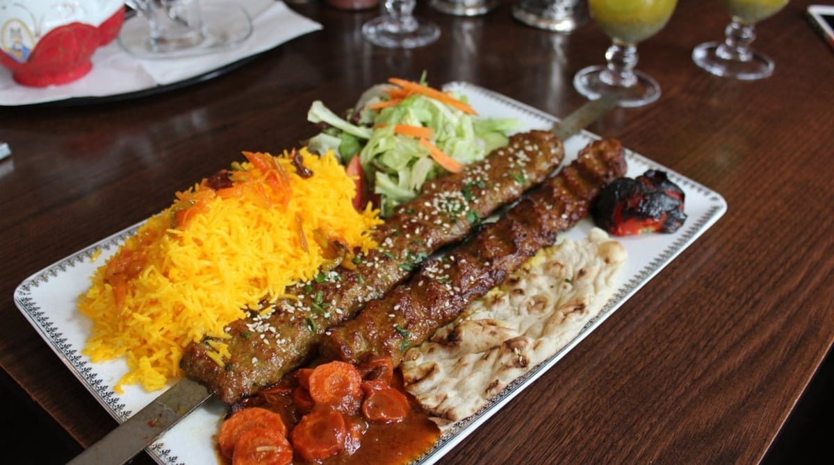 Gegrillte Hackfleischspieße mit Safranreis und Tomate im Shandiz