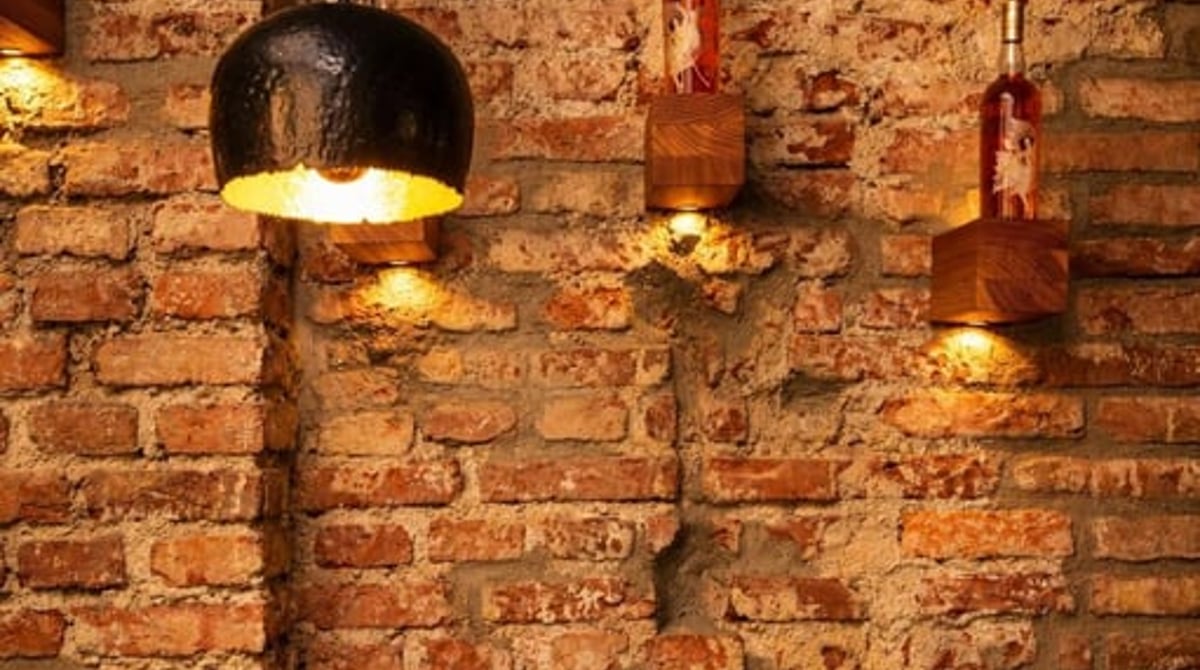 Backsteinwand mit Wandlampe und gedecktem Tisch im MOZZAMO Romanplatz