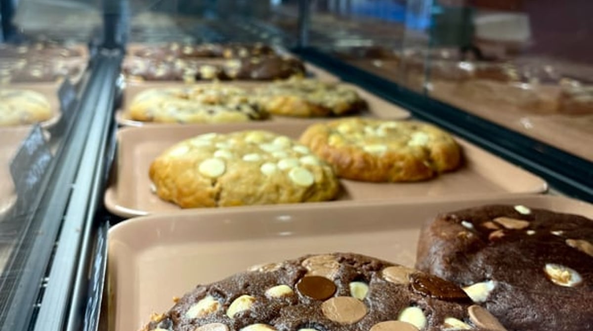 Vitrine mit frisch gebackenen Cookies auf Blechen