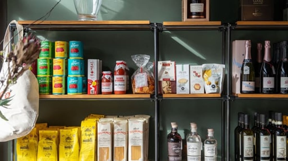 Regal im Shop mit italienischer Pasta, Tomaten und Weinflaschen