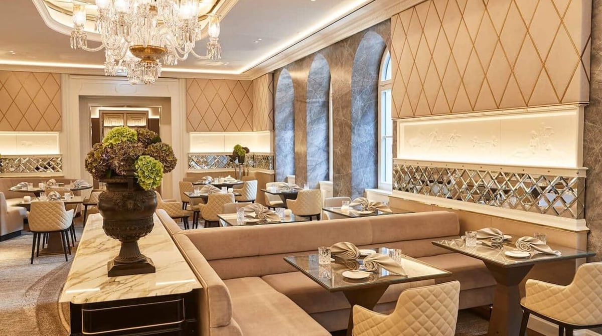 Gastraum des Restaurants Schwarzreiter mit Kristalllüster, gepolsterten Sitzbänken und gedeckten Tischen