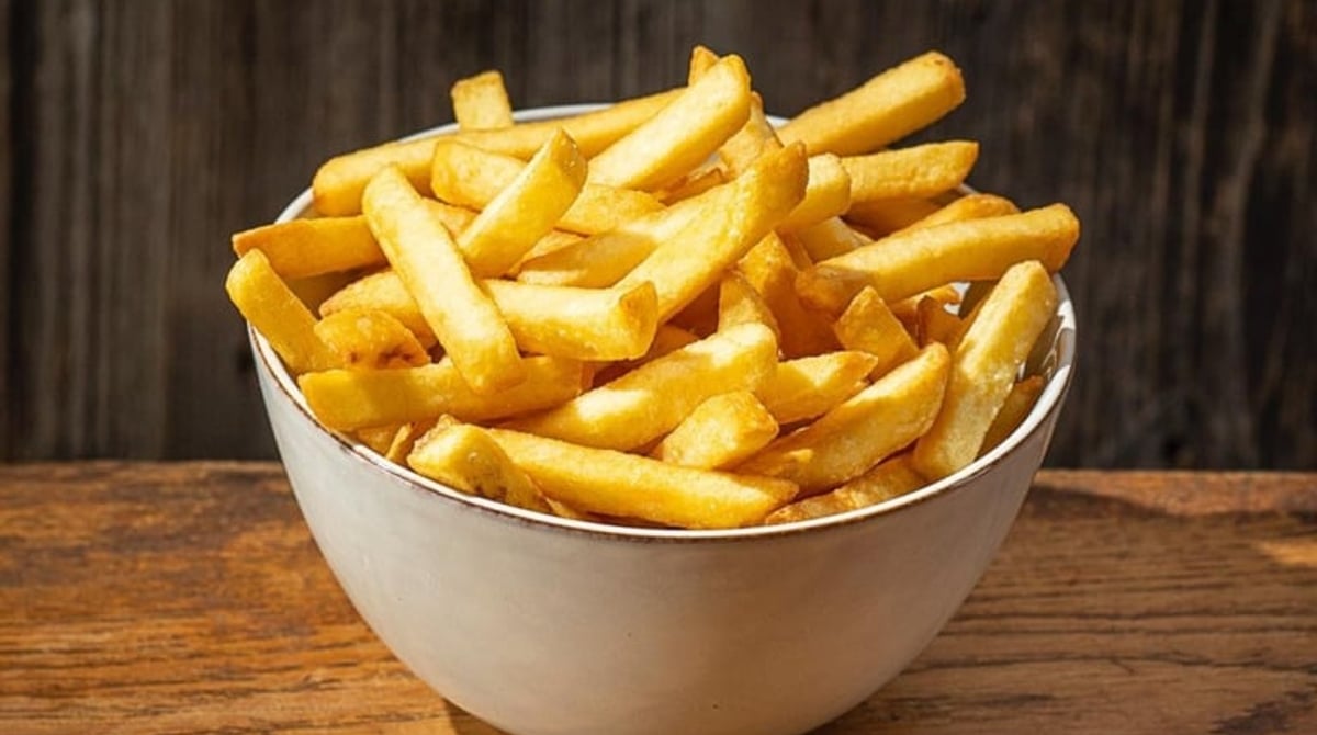 Schale mit Pommes auf einem Holztisch