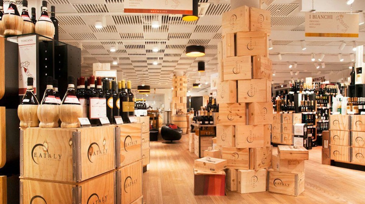 Die Weinabteilung L'Enoteca bei Eataly in München mit Holzkisten und Weinregalen