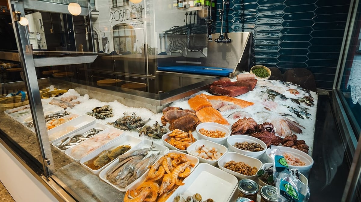 Fischtheke des Poseidon mit Lachs, Garnelen, Muscheln und Feinkostsalaten