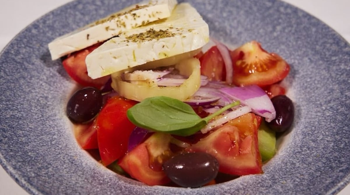 Griechischer Bauernsalat mit Feta und Oliven in einer blauen Schale im Paros