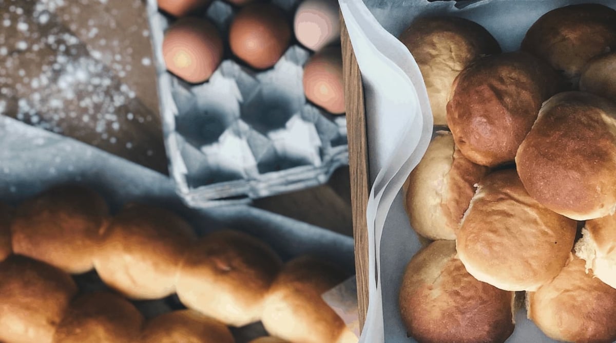Frisch gebackene Mini-Burger-Semmeln und Eier in der Backstube
