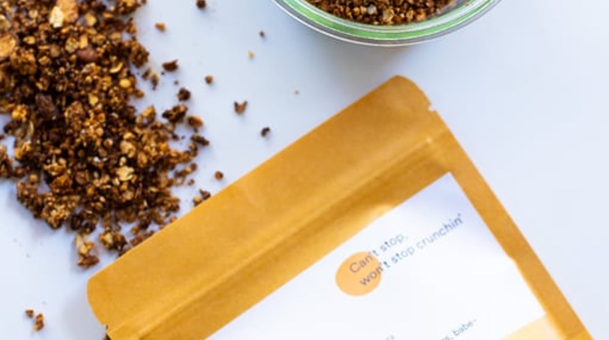 Glas mit hausgemachtem Granola und gelbe Tüte mit Granola