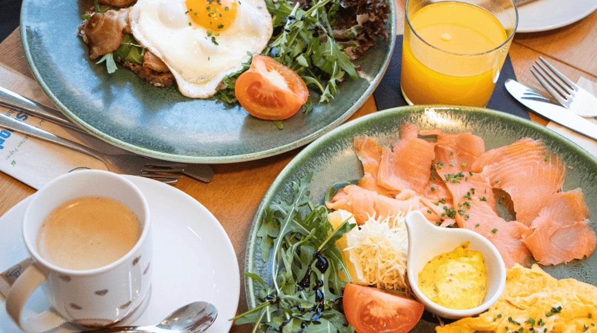 Frühstück bei Rischart mit Spiegelei, Lachs, Rührei, Orangensaft und Kaffee