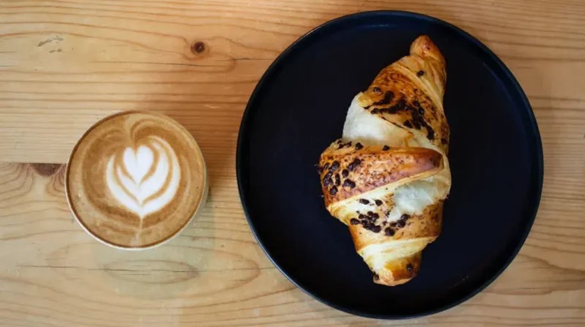 Cupcake mit Nüssen und eine Tasse Kaffee auf einem Holzbrett