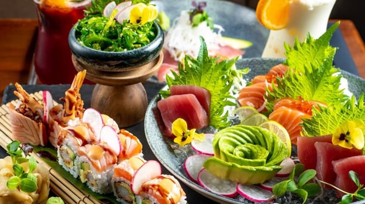 Sushi-Rollen und Nigiri mit Lachs und Thunfisch auf einem Holzbrett im Zento