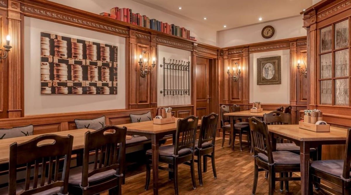Holzvertäfelte Gaststube in Paulaner's Wirtshaus im Westin Grand mit Holztischen und Stühlen