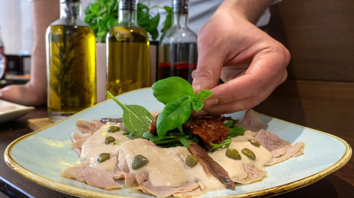 Vitello Tonnato mit Kapern und Basilikum auf einem Teller