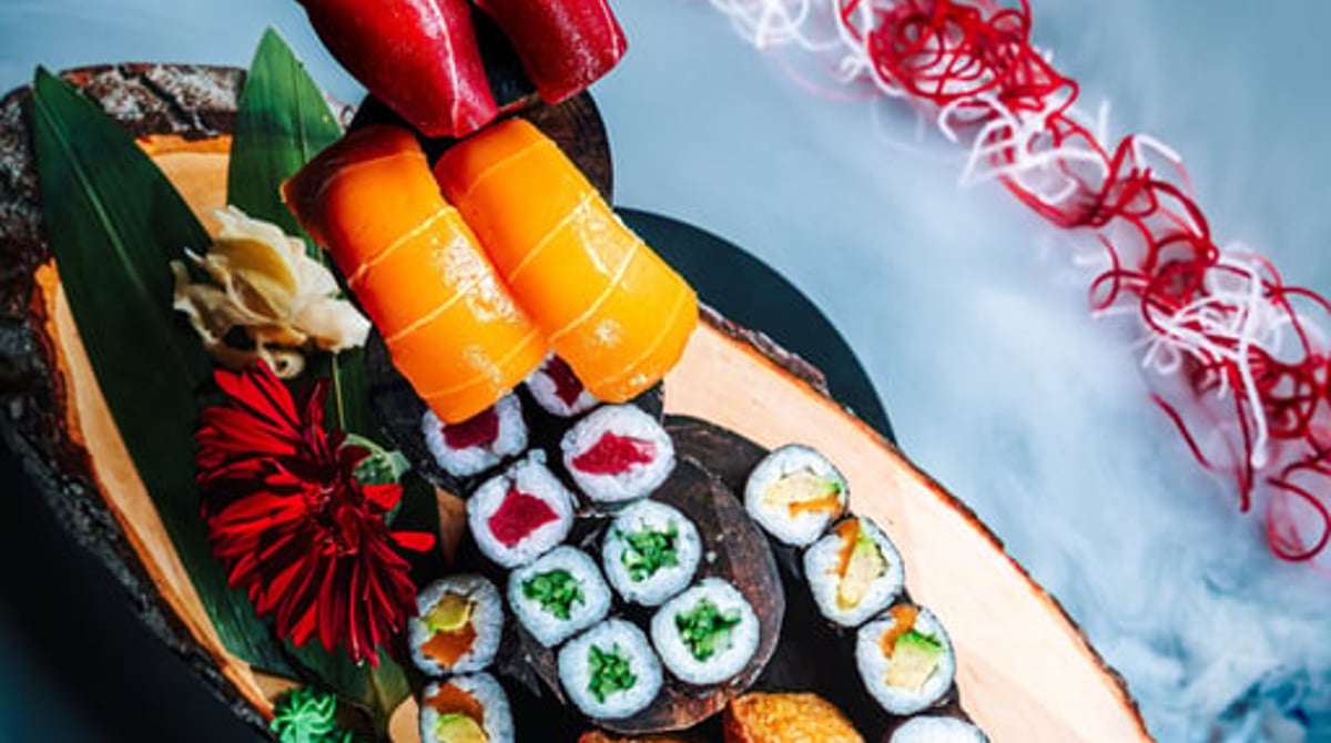 Veganes Sushi mit Nigiri, Maki und Inari auf einem Holzboot
