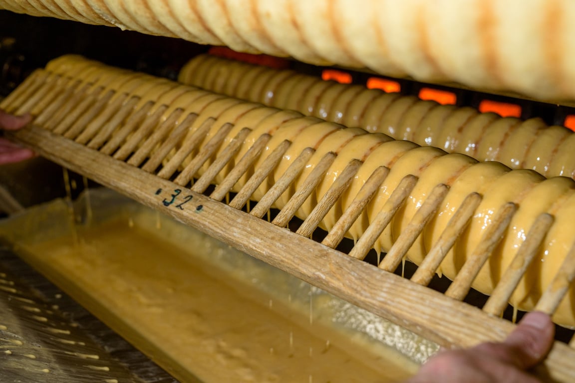 Baumkuchen-Walze mit goldenem Teig über der Flamme