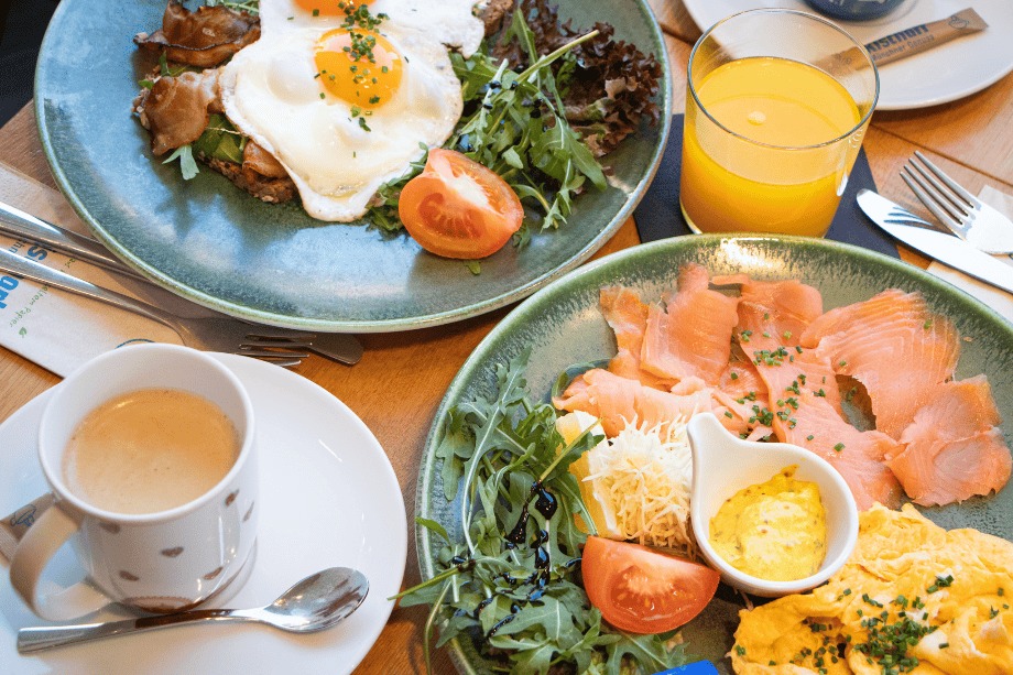 Frühstück bei Rischart mit Spiegelei, Lachs, Rührei, Orangensaft und Kaffee