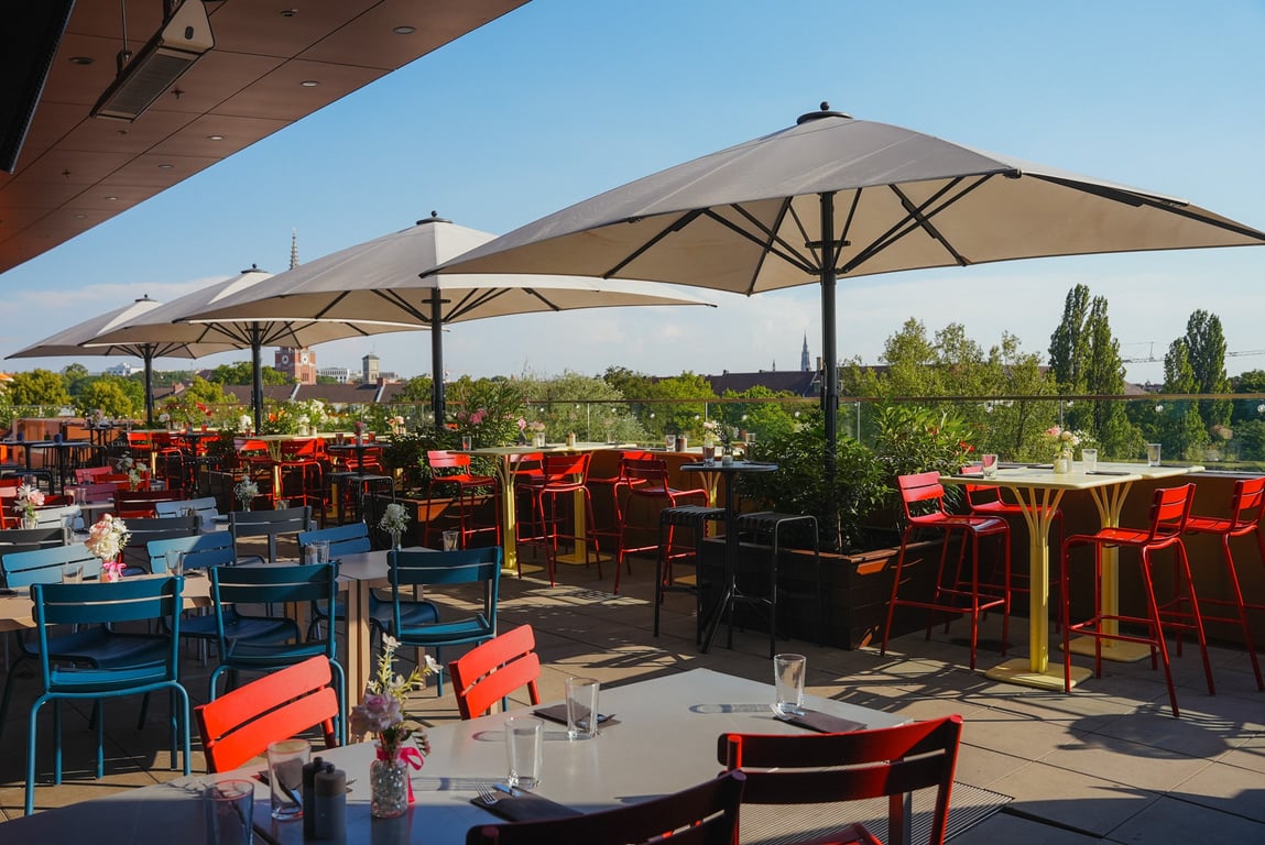 Dachterrasse der Frau im Mond mit Sonnenschirmen und Blick über die Isar