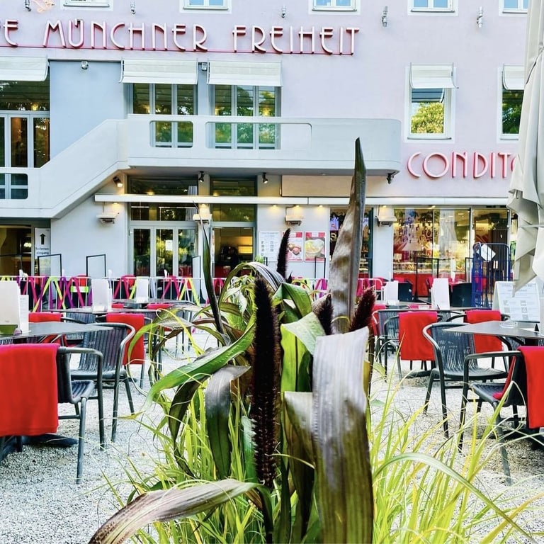 Die Terrasse des Café Münchner Freiheit mit Tischen und roten Tischdecken