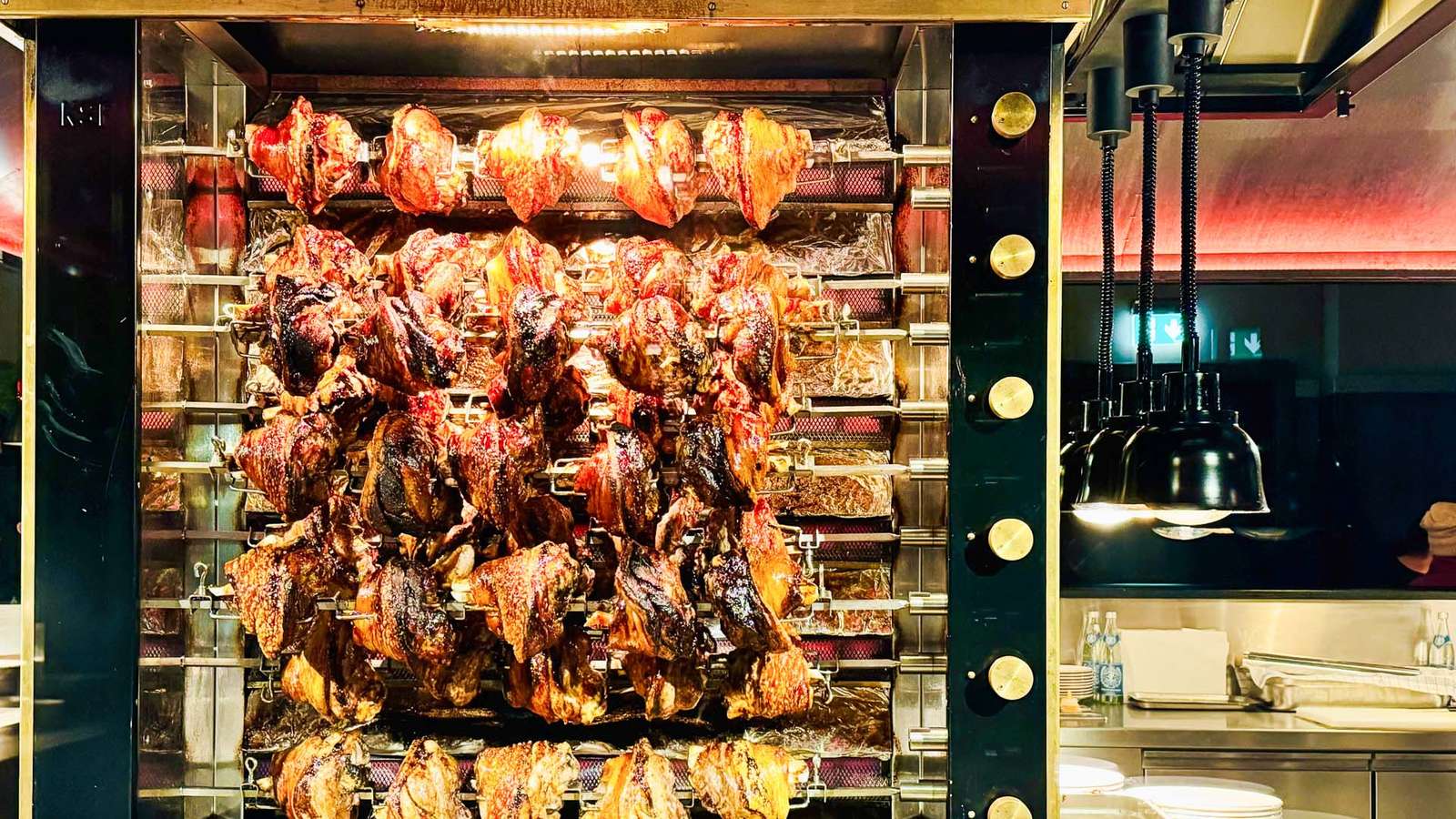 Schweinshaxen drehen sich am Spießgrill in der offenen Küche des Haxengrill