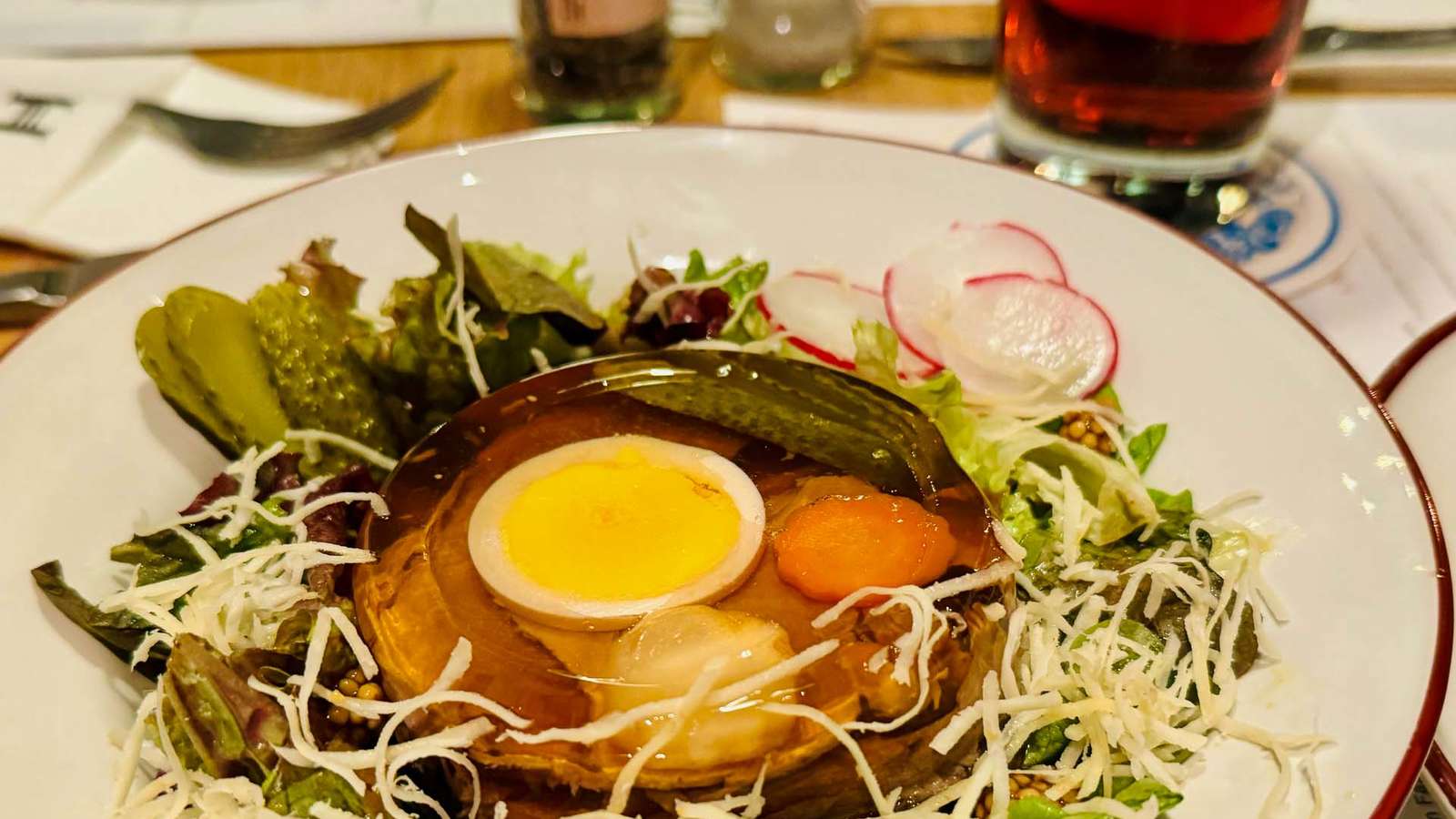 Hausgemachte Haxengrill-Sülze mit Ei und Gemüse auf Blattsalat mit Radieschen