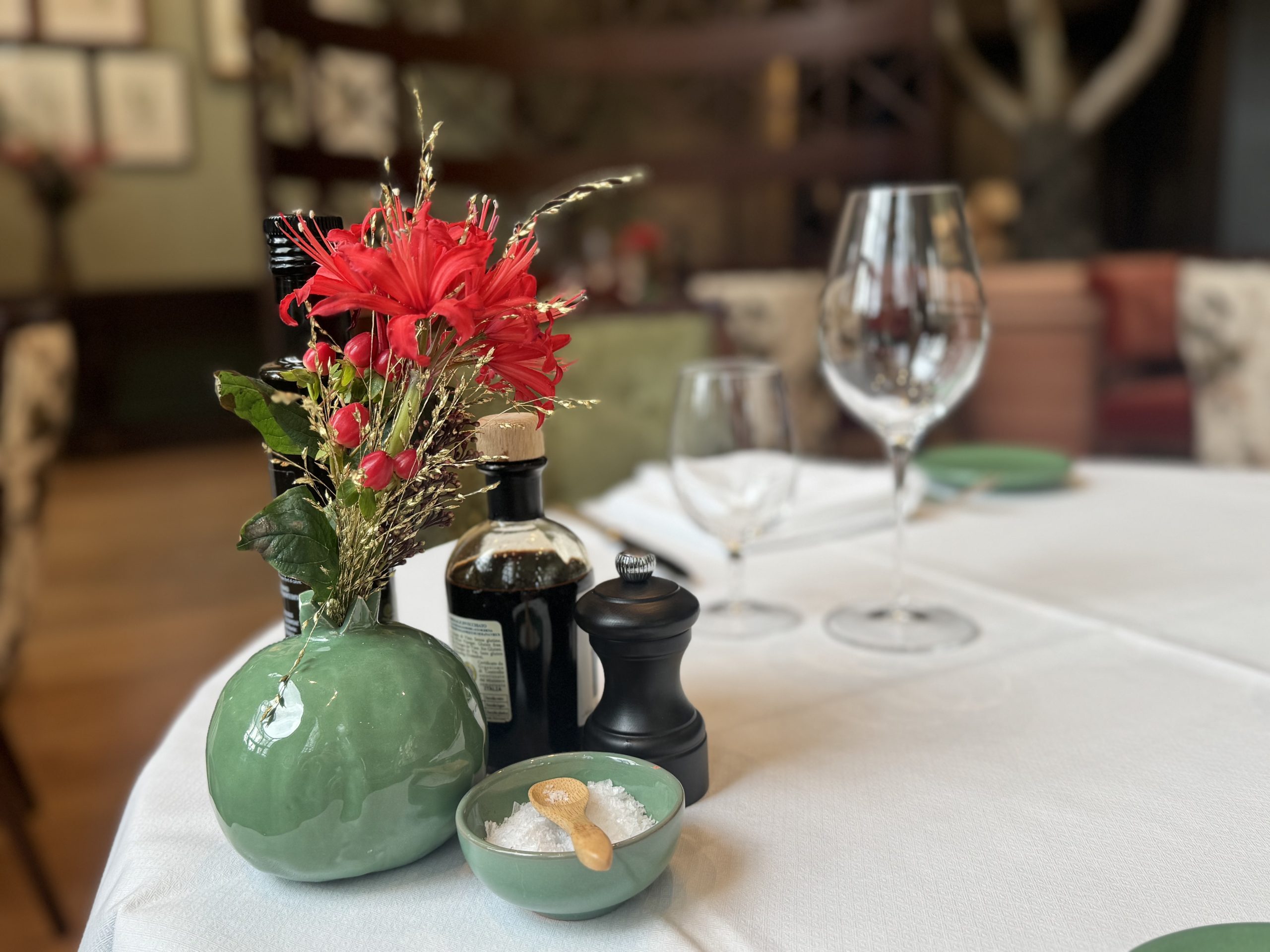 Weiß eingedeckter Tisch im Florio mit Vase, Pfeffermühle, Olivenöl und Salz
