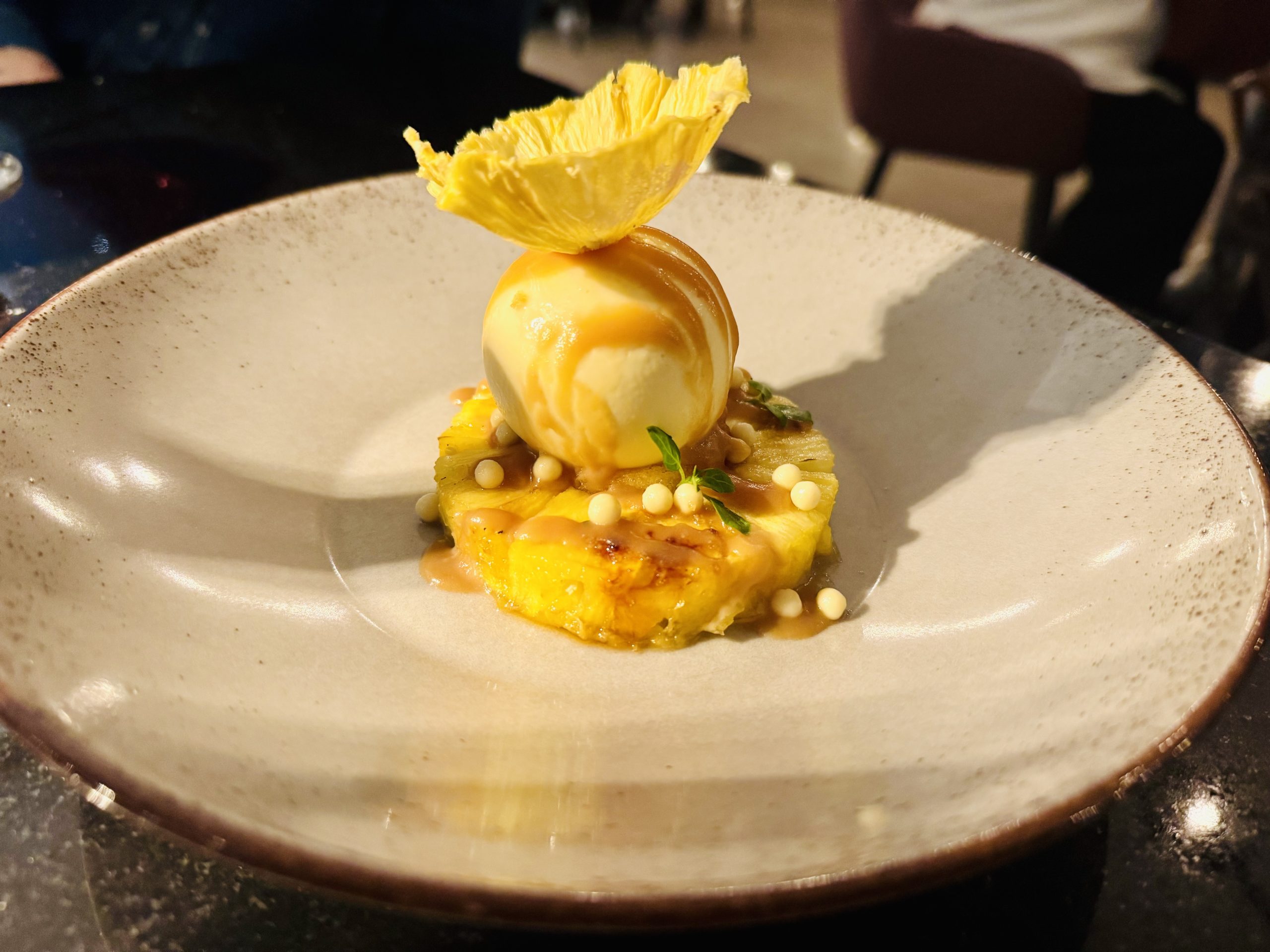 Dessert mit Ananas, Quarkbällchen und weißer Kuvertüre