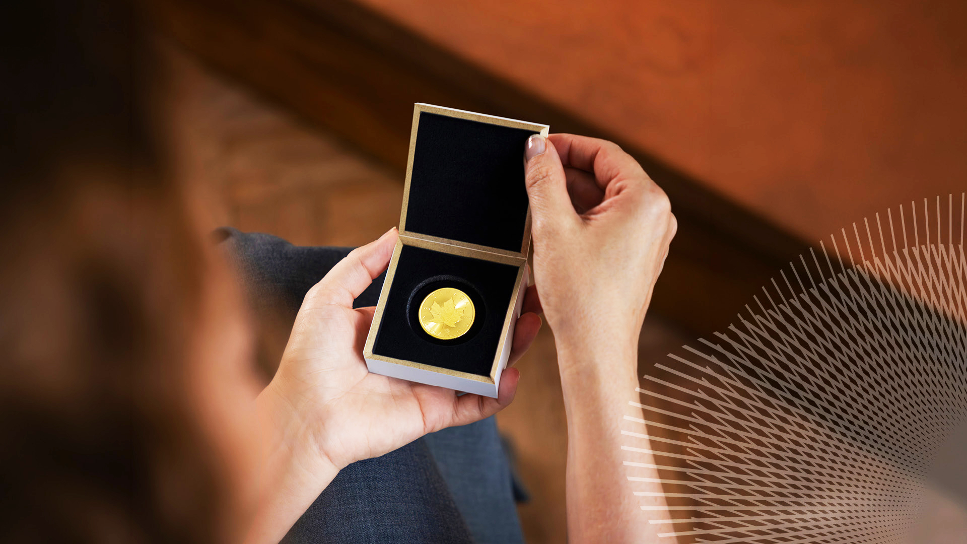 Person holds an open small display box showing a gold coin with a black interior.