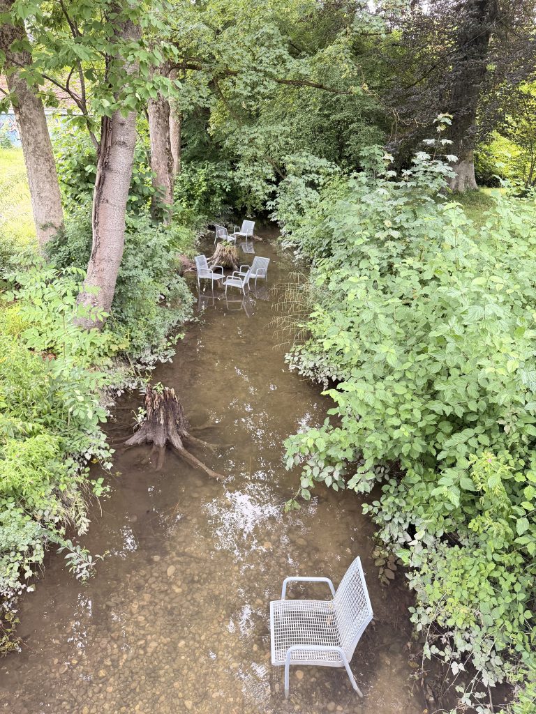 freibadbächl-rosengarten-muenchen - IN München - Das Stadtmagazin Graue Metallstühle im Freibadbächl im Rosengarten München