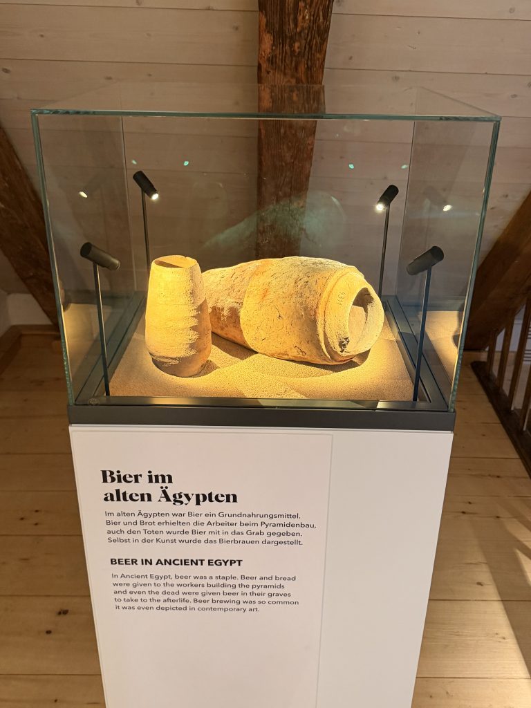 Biermuseum-muenchen-exponat-aegypten - IN München - Das Stadtmagazin Exponat mit Steinkrüge, die auf Sand liegen im Biermuseum München