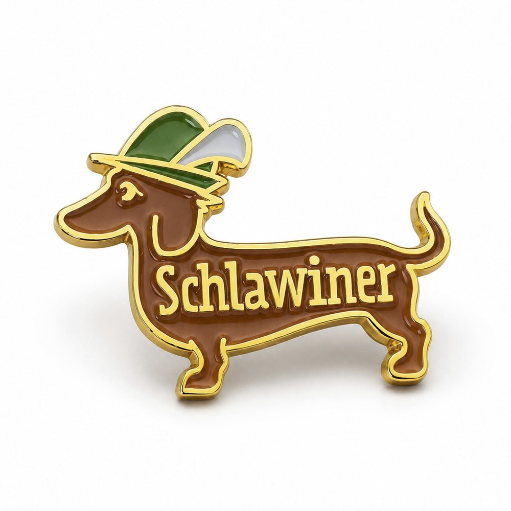 Enamel dachshund pin with gold outline, wearing a green hat, text reads 'Schlawiner'