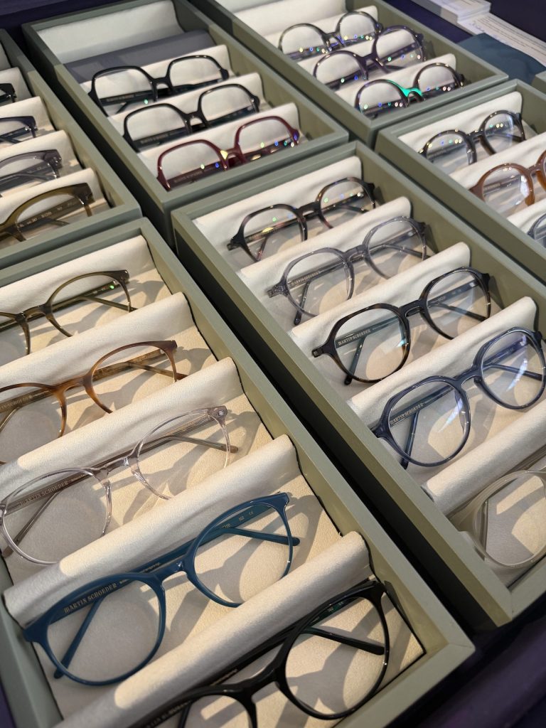 image2Baumanis - IN München - Das Stadtmagazin Rows of eyeglasses neatly arranged in padded display compartments at a store