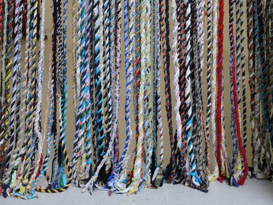 kunstpavillion Nakajima - IN München - Das Stadtmagazin Colorful twisted rope strands hanging vertically in multiple rows against a neutral background.